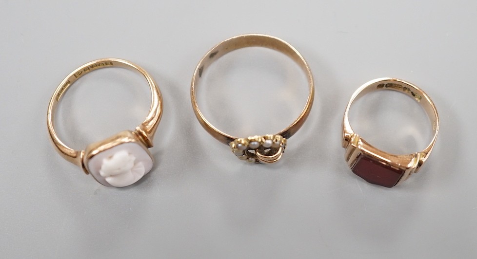 A late Victorian 9ct gold and carnelian set signet ring, size G and tow later 9ct rings including seed pearl buckle and cameo, gross weight 10 grams.